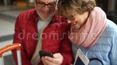 女人和男人看着智能手机屏幕，开心地笑着。 两人都穿着春装，两人都穿